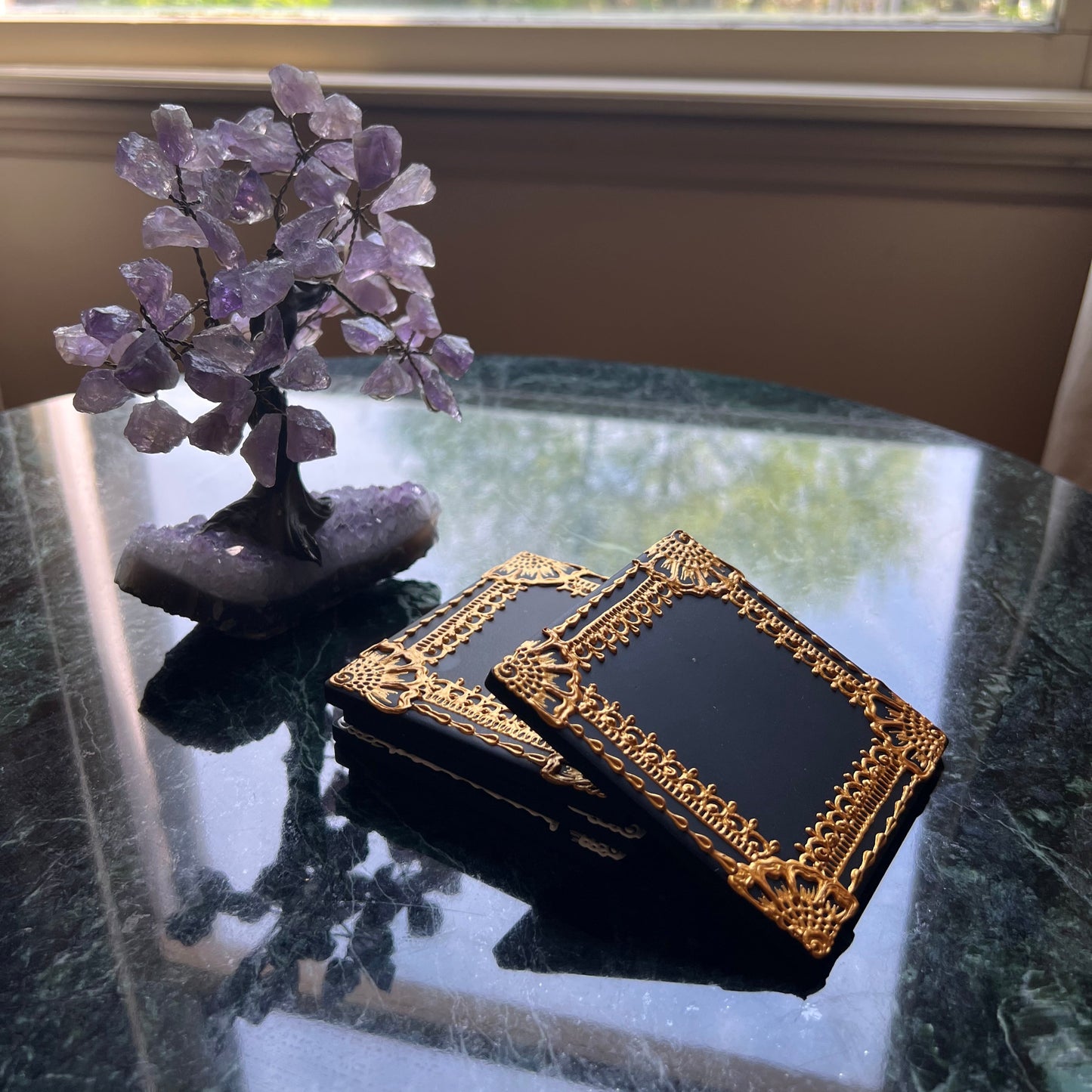 Side view of square ceramic coaster with hand-painted gold henna border on black tile, showing raised texture. Set of Four