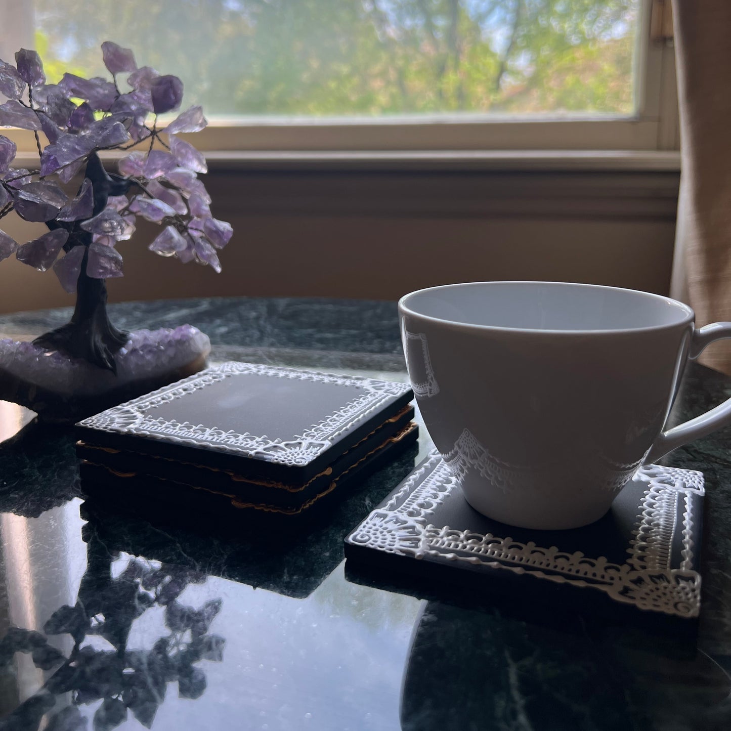 White henna ceramic coaster on black tile shown with tea cup, styled for modern boho table decor